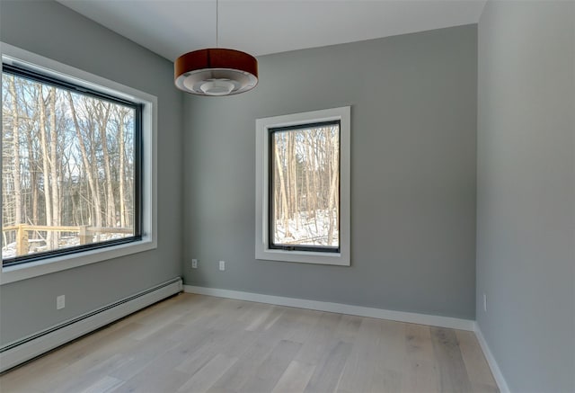 empty room with light wood-type flooring and a baseboard radiator