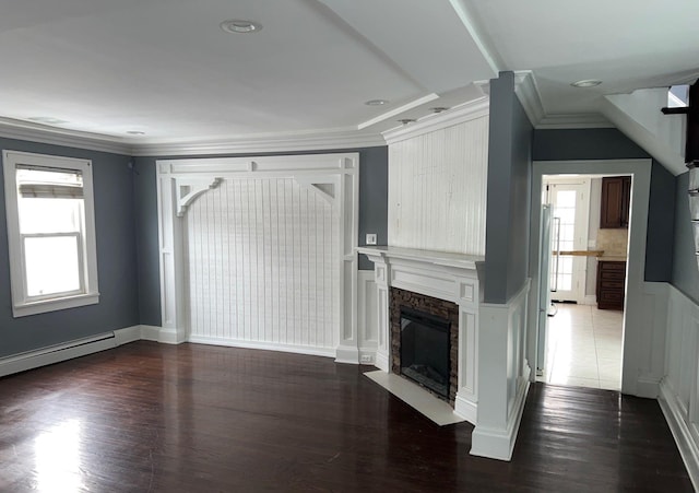 unfurnished living room featuring plenty of natural light, a fireplace, ornamental molding, and dark wood-type flooring