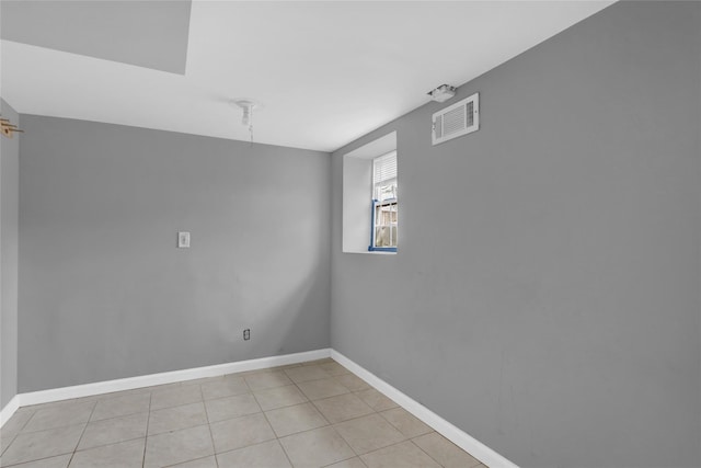 spare room featuring light tile patterned floors, baseboards, and visible vents