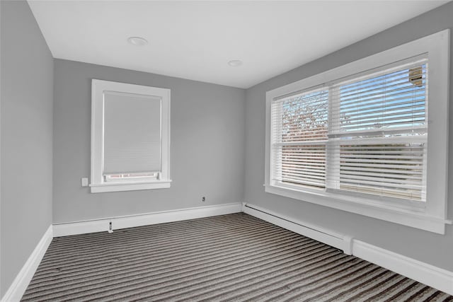 empty room featuring baseboards and dark carpet