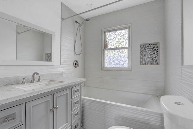 full bathroom with toilet, vanity, and tiled shower / bath