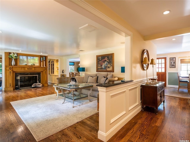 living room featuring a high end fireplace, dark wood-style flooring, wainscoting, and recessed lighting