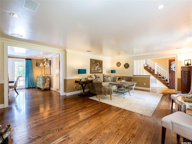 living room featuring stairs, ornamental molding, wood finished floors, and baseboards