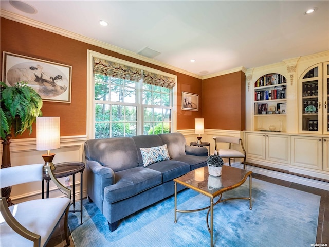 living room with a wainscoted wall, built in features, crown molding, and recessed lighting