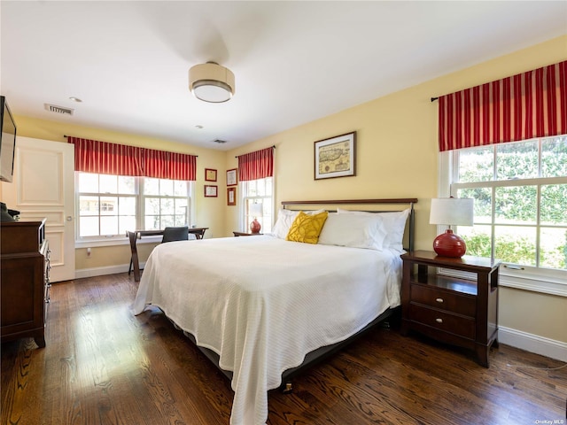 bedroom featuring visible vents, baseboards, and dark wood finished floors