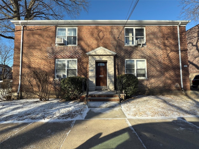 colonial house with cooling unit and brick siding