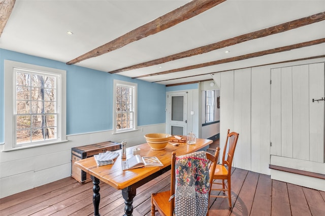 dining space with dark hardwood / wood-style floors and beam ceiling