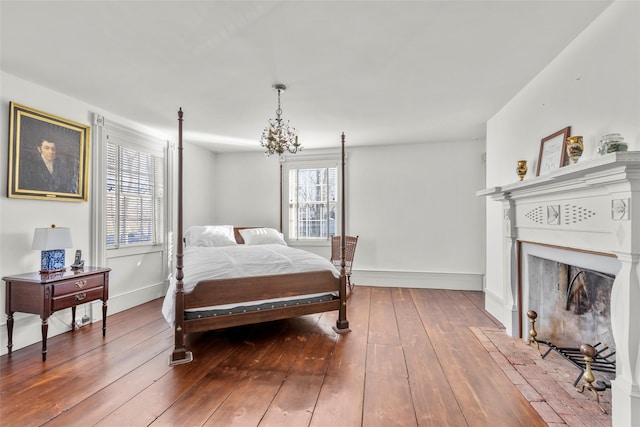 bedroom with multiple windows, hardwood / wood-style flooring, and a notable chandelier