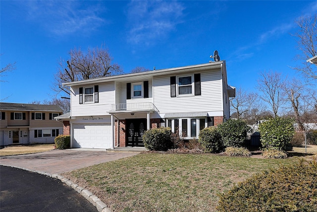 view of front facade featuring brick siding, fence, a front yard, driveway, and an attached garage