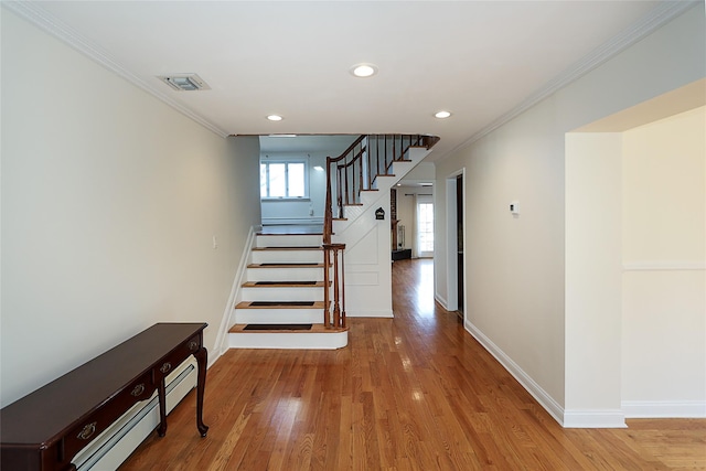 stairway featuring visible vents, crown molding, baseboards, and wood finished floors