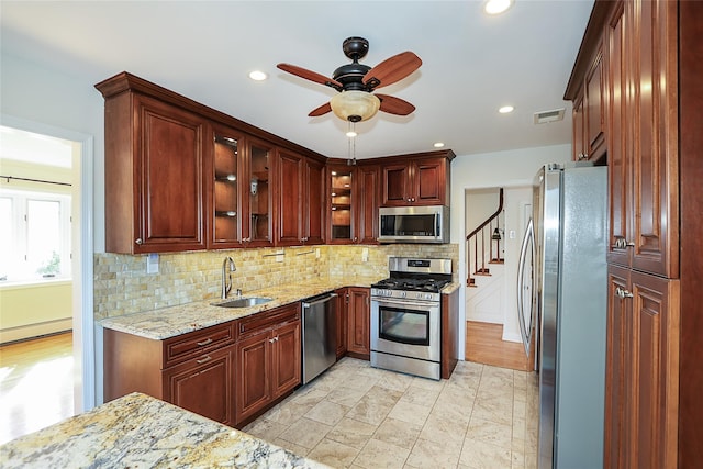 kitchen with a ceiling fan, visible vents, a sink, stainless steel appliances, and backsplash