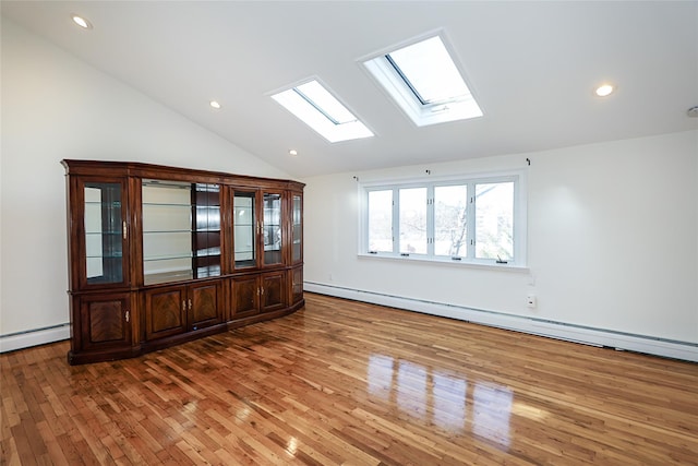 unfurnished room with lofted ceiling with skylight, recessed lighting, light wood-style floors, and a baseboard radiator