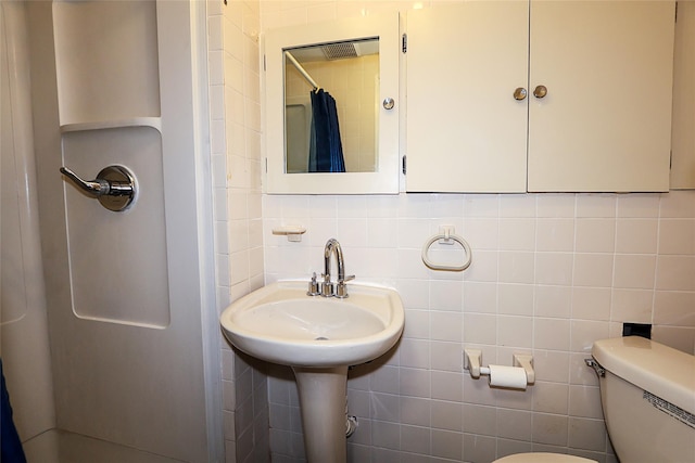 full bath with a shower with shower curtain, toilet, tile walls, and tasteful backsplash