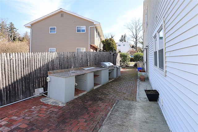 view of patio / terrace with a grill, exterior kitchen, and a fenced backyard