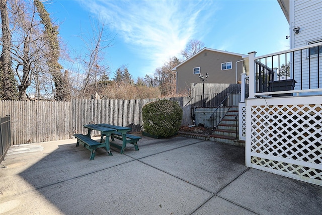 view of patio / terrace with outdoor dining area, fence, and stairway