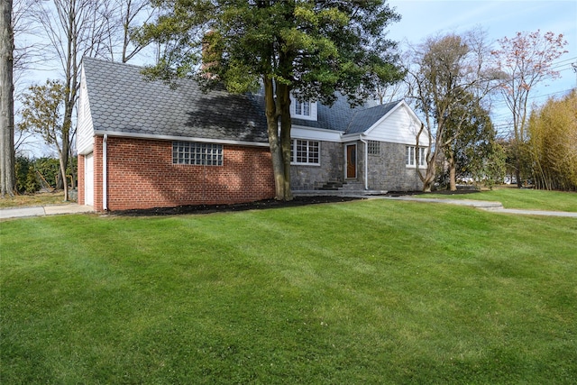 view of front of house featuring brick siding, concrete driveway, a front lawn, and stone siding