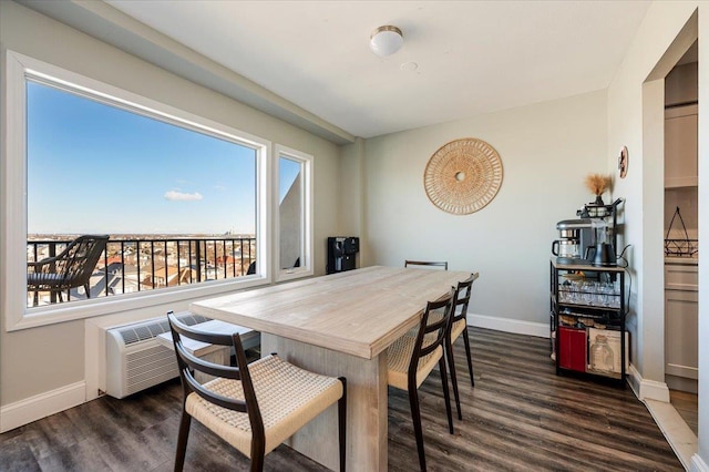 dining space featuring a wall mounted air conditioner, baseboards, and wood finished floors