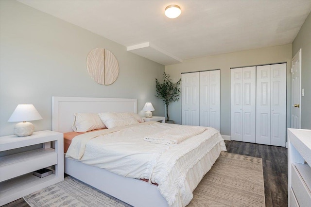 bedroom featuring wood finished floors and multiple closets