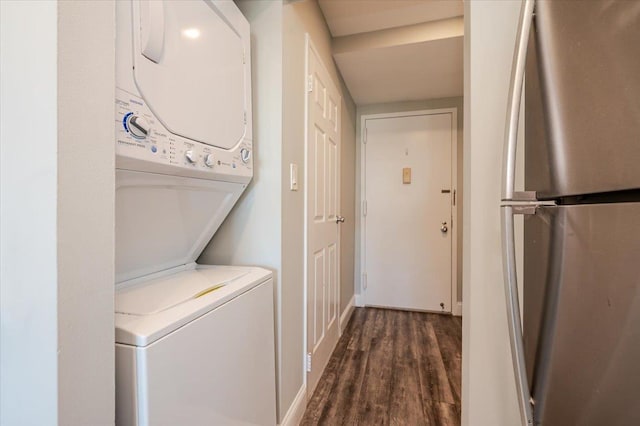 clothes washing area featuring laundry area, dark wood finished floors, and stacked washer and clothes dryer