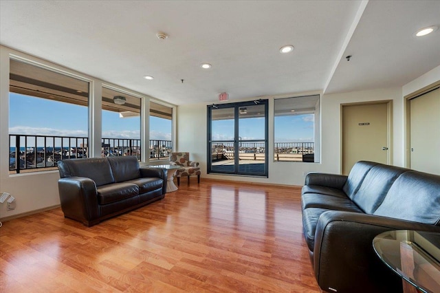 living room featuring baseboards, light wood-style flooring, and recessed lighting