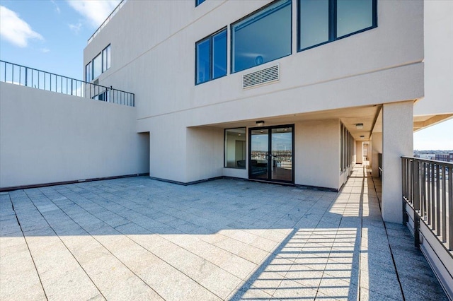 rear view of house with a patio and stucco siding