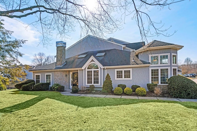 view of front of house featuring stone siding, a shingled roof, a chimney, and a front yard