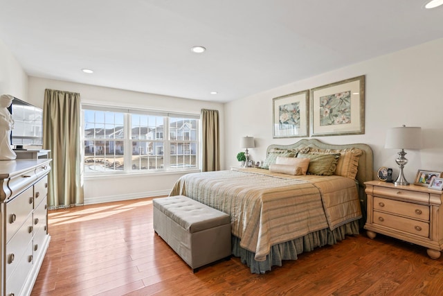 bedroom featuring baseboards, wood finished floors, and recessed lighting