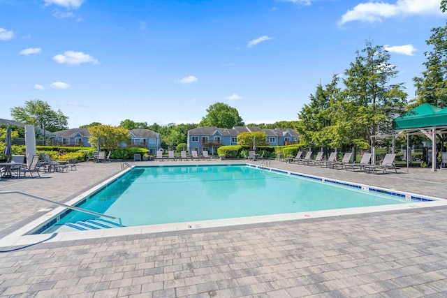 community pool with a patio and fence