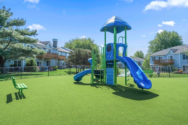 community play area with a yard and fence