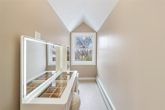 interior space featuring a baseboard heating unit, lofted ceiling, and baseboards