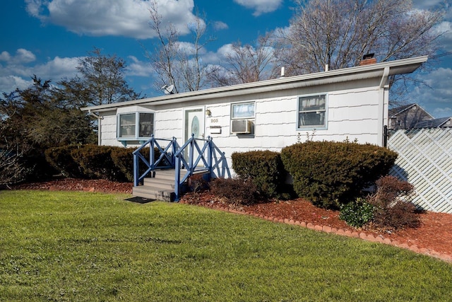 view of front of home with a front yard, cooling unit, fence, and a chimney