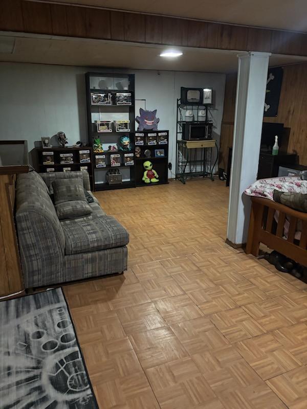 203 Front Ave, Brentwood, NY 11717 - living room featuring wood walls