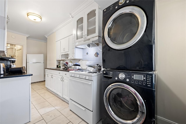 washroom featuring crown molding, laundry area, light tile patterned floors, and stacked washer / drying machine