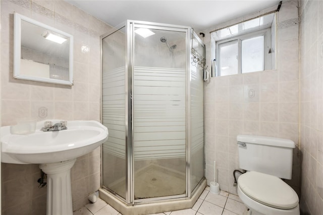 full bath featuring a stall shower, tile patterned flooring, tile walls, and toilet