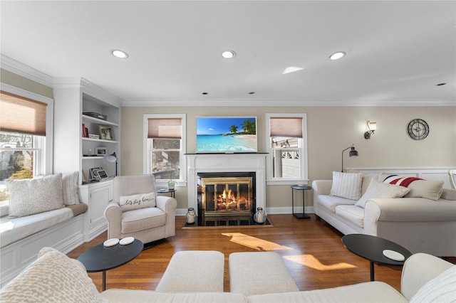 living room with a fireplace with flush hearth, recessed lighting, ornamental molding, and wood finished floors