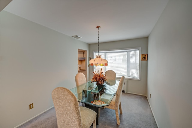 dining space with baseboards, visible vents, and light colored carpet