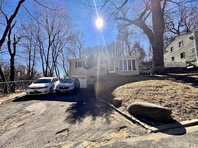 view of side of home with driveway and fence