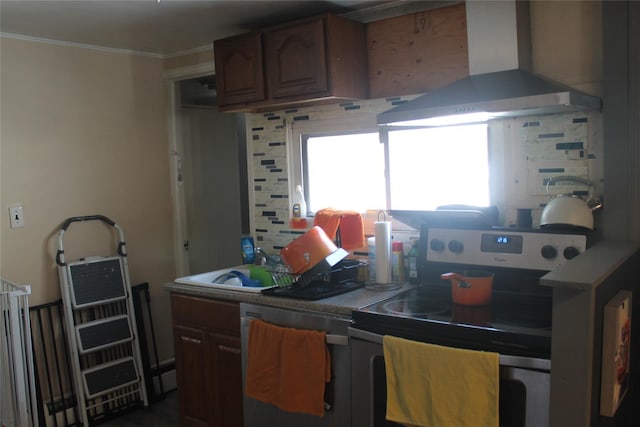 kitchen featuring wall chimney range hood, appliances with stainless steel finishes, crown molding, and tasteful backsplash