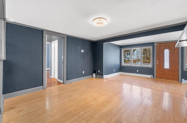 empty room with light wood-type flooring and baseboards