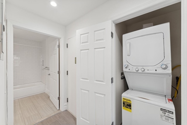 clothes washing area with stacked washer and clothes dryer, laundry area, and recessed lighting