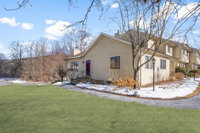 exterior space featuring a lawn and a chimney