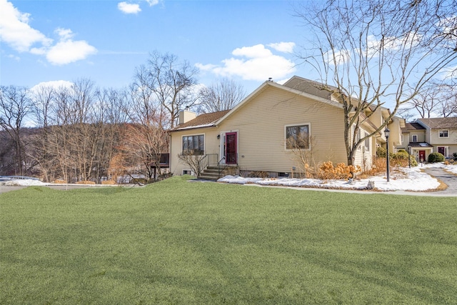 view of front of house featuring a chimney and a front lawn