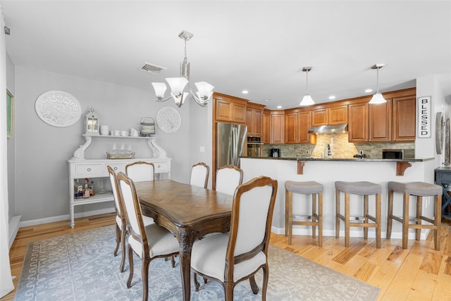 dining space featuring light wood finished floors, recessed lighting, visible vents, and a notable chandelier