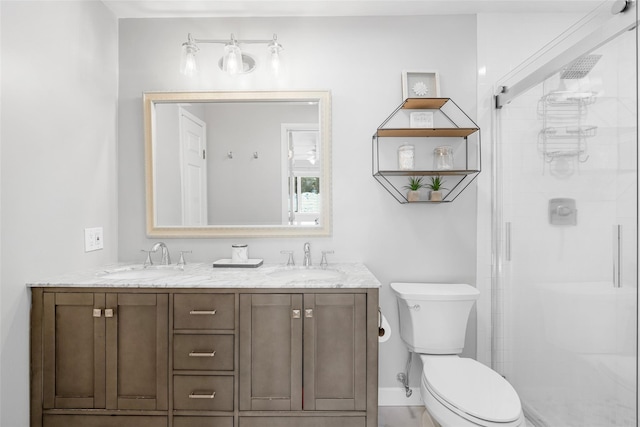 bathroom with toilet, a shower stall, double vanity, and a sink