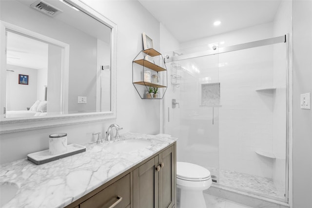 bathroom with toilet, vanity, visible vents, and a shower stall