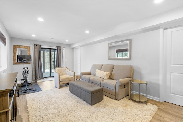 living room featuring baseboards, recessed lighting, and light wood-style floors