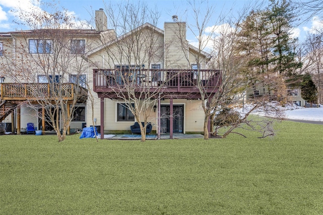 rear view of house featuring a yard, a chimney, a patio, and a wooden deck