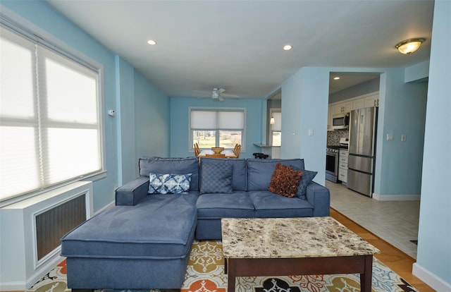 living area with baseboards, radiator heating unit, recessed lighting, and ceiling fan