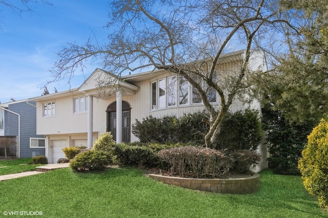 raised ranch with a garage and a front yard