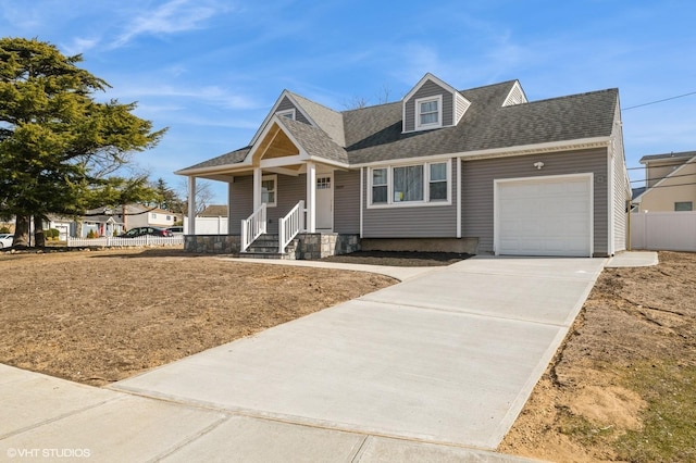 view of front of house with a porch, an attached garage, a shingled roof, fence, and concrete driveway